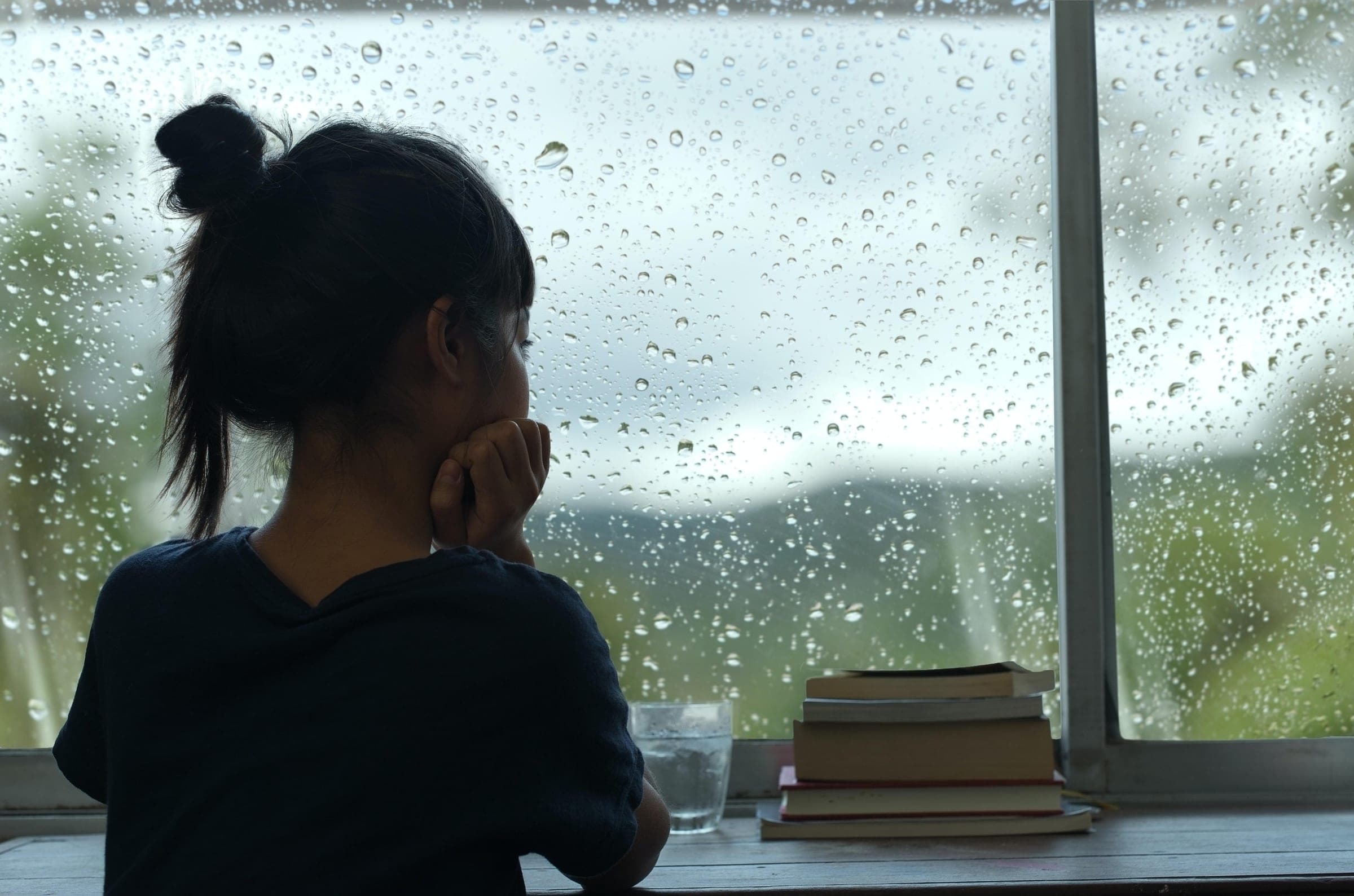 Nachdenkliche Person blickt aus dem Fenster – Sinnbild für Gedanken, die im Arbeitsalltag oft unausgesprochen bleiben